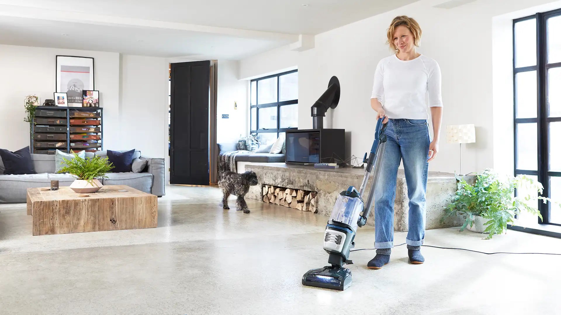 Woman with vacuum cleaner and dog vacuuming with Vacmaster Respira Lift Off Pet