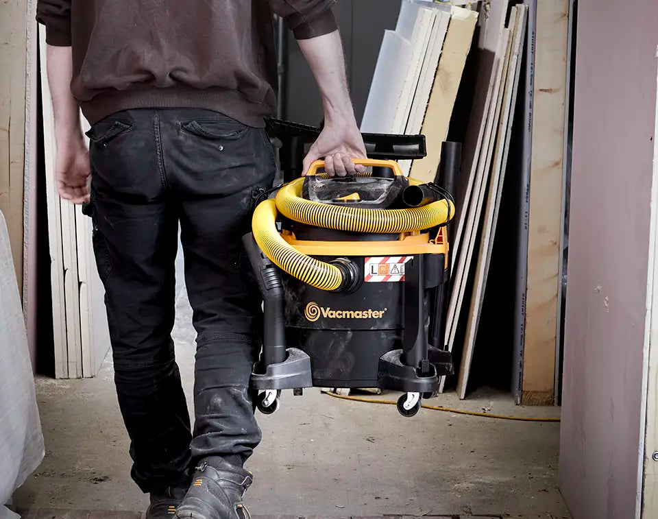 Dust Extractor wet and dry vacuum cleaner from Vacmaster being carried through building site
