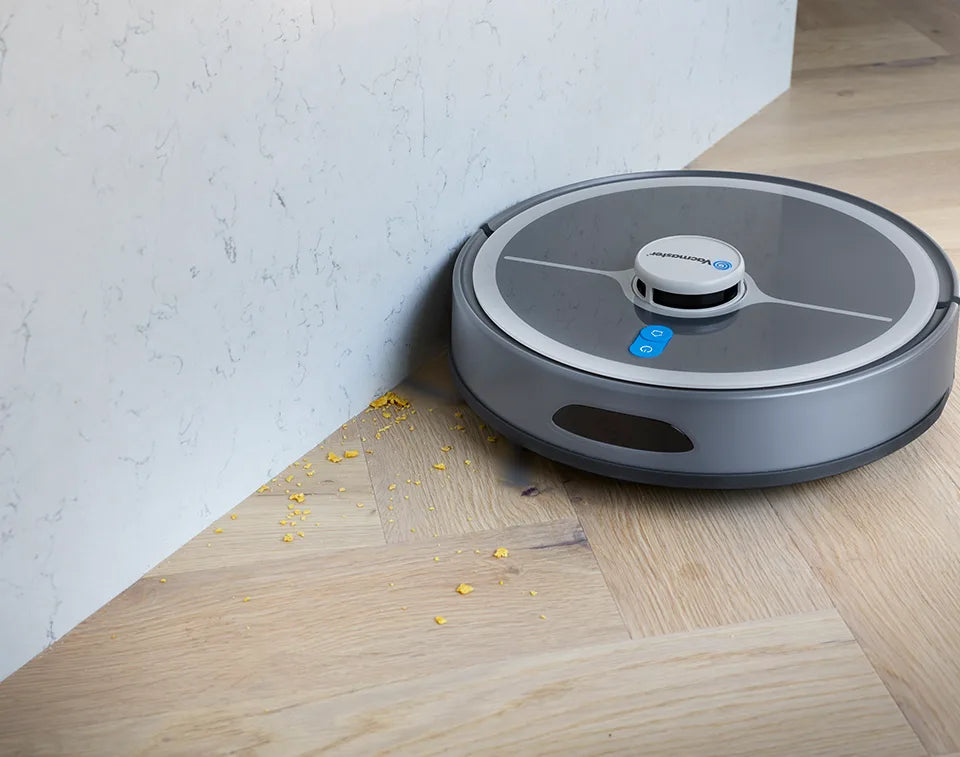 Robot vacuum cleaner Vacmaster REi cleaning crumbs from edge with brushes in kitchen 