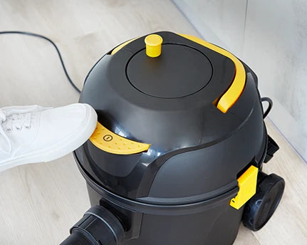 Foot turning on vacuum cleaner power switch on Vacmaster D8