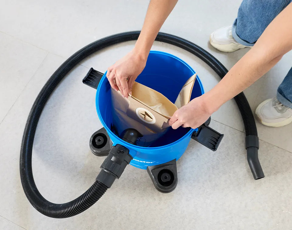 Inserting dust bag into Vacmaster Multi WD16 wet and dry vacuum cleaner