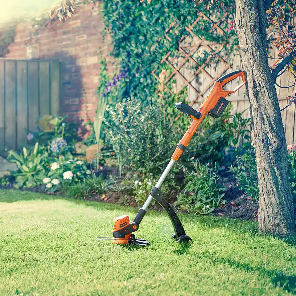 Lawnmaster MX 24V Cordless Grasstrimmer againts tree UK Garden